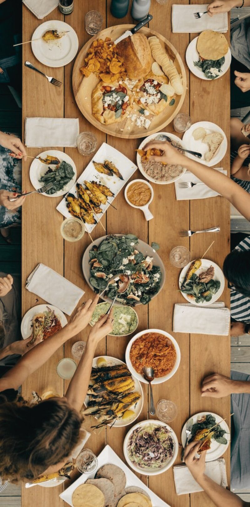 The Power of Family Gatherings Around the Dinner Table Overhead view of a family gathering around a dinner table filled with a variety of healthy dishes, showcasing the power of meal planning in bringing the family together for meaningful conversations and shared experiences.