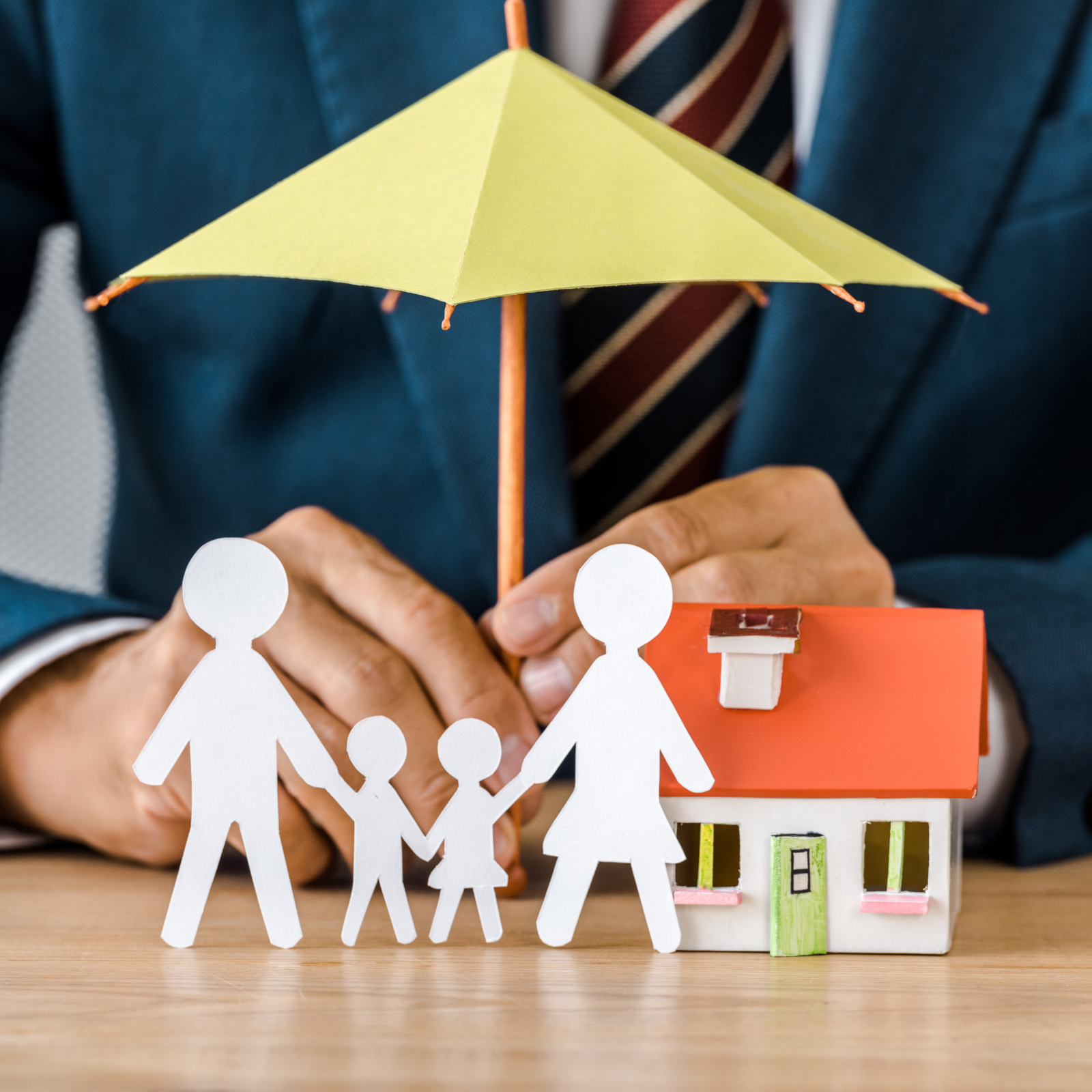 Protect Your Family with Life Insurance Living Benefits Life insurance concept - family figures under an umbrella with a house, symbolizing financial protection and living benefits.