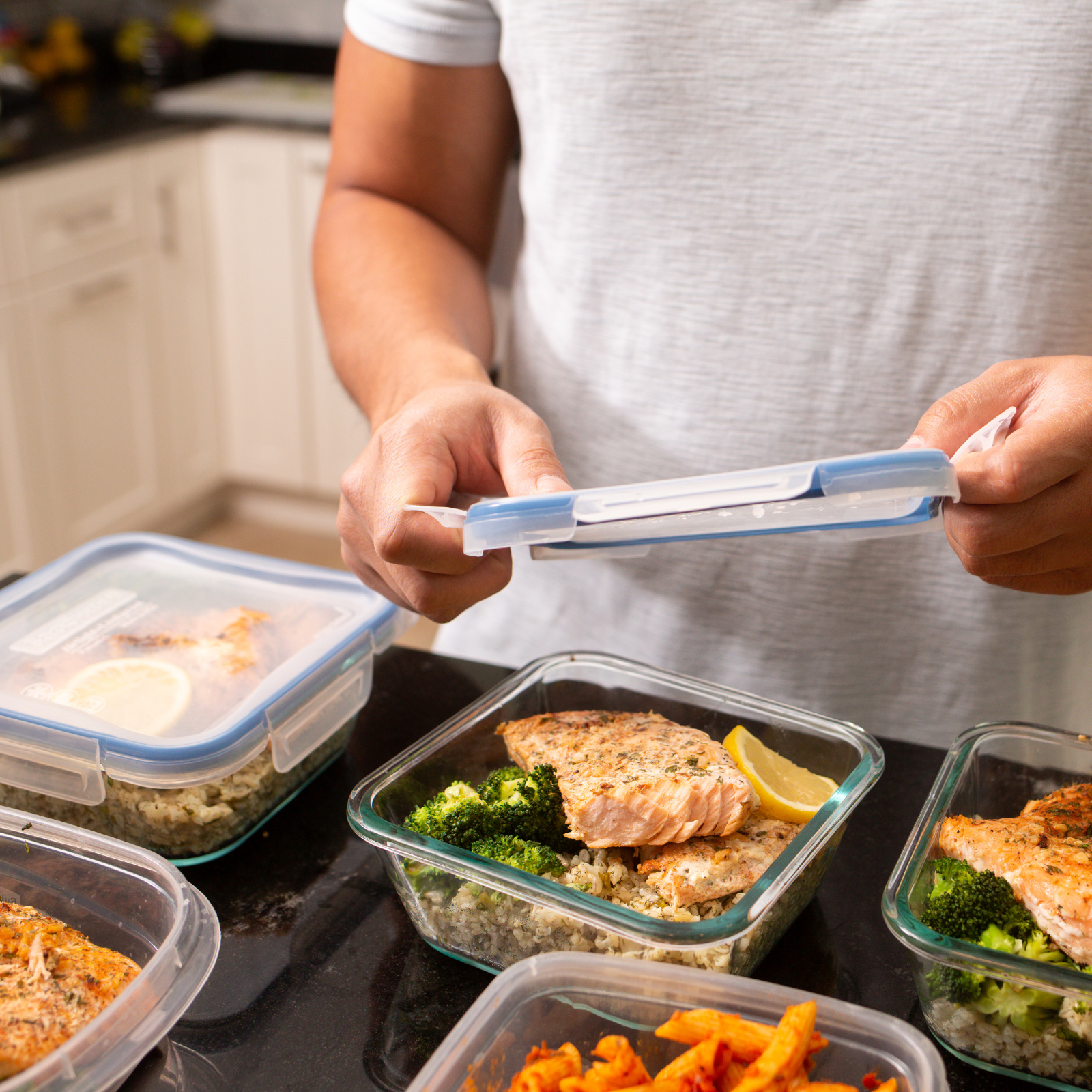 Simplify Mealtime with Healthy Meal Prep "Person preparing healthy meal prep containers with salmon, broccoli, and rice for a week of nutritious, stress-free meals."