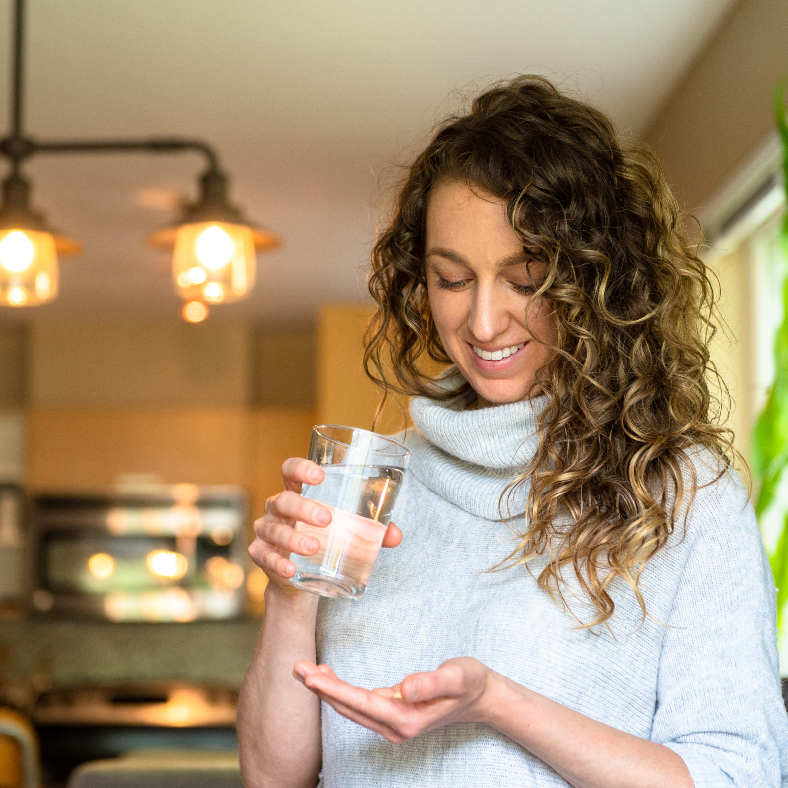 Daily Wellness Routine: Juice Plus in Action "Woman holding a glass of water and Juice Plus capsules, symbolizing a healthy daily wellness routine."