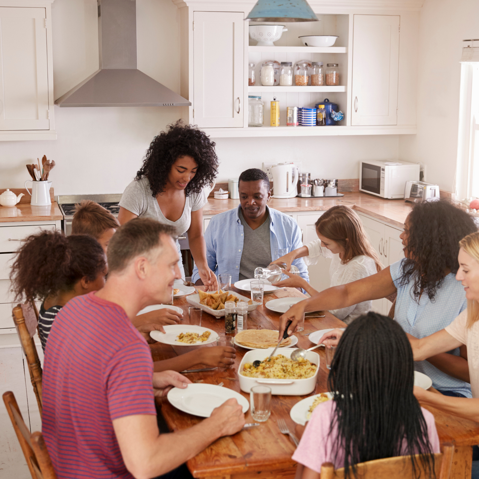 Family Gatherings Made Easy with Fun, Healthy Meal Plans A family gathered around a dinner table, sharing a meal and enjoying quality time together, symbolizing the value of fun, nutritious meal plans for families.