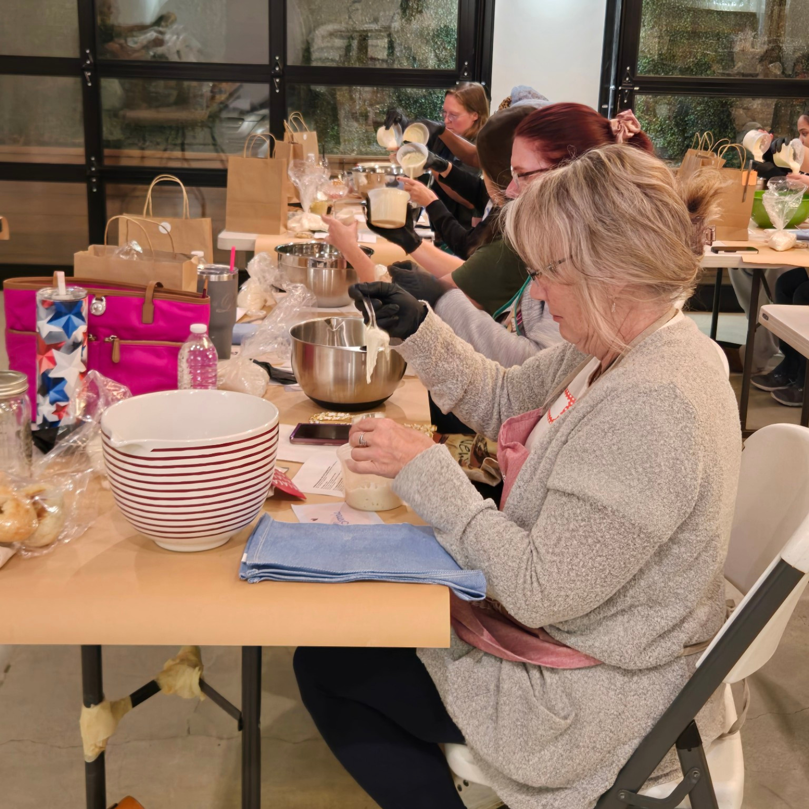 Engaging in a Hands-On Sourdough Workshop Participants mixing sourdough starter and preparing dough during a hands-on sourdough workshop led by Rachael DeBoy.