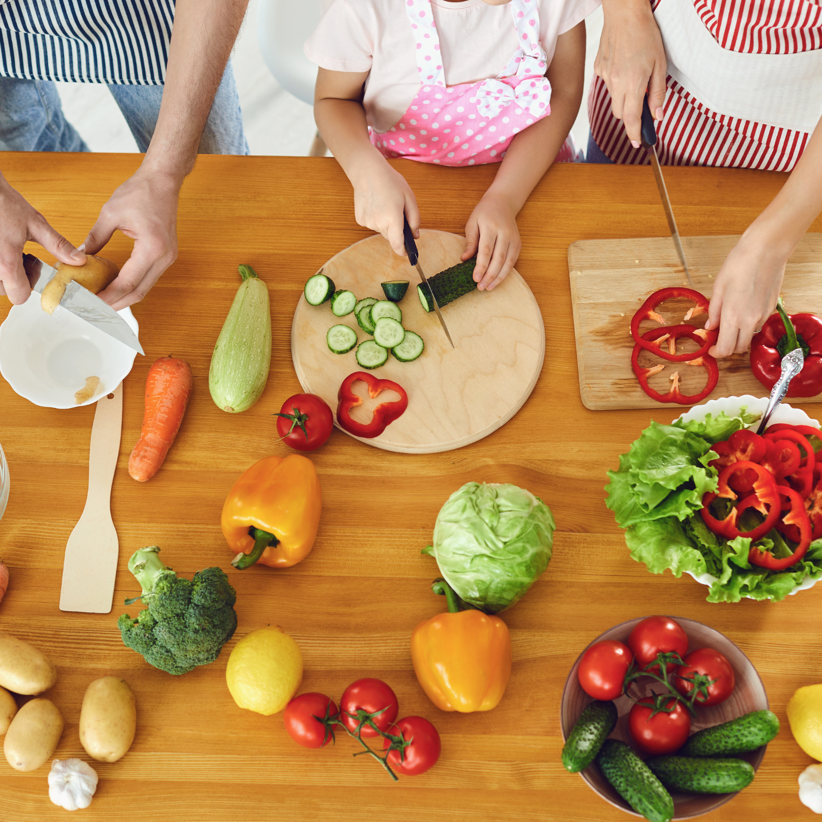 Cooking Together: Healthy Habits Start in the Kitchen Family preparing fresh vegetables together at the table, including peppers, cucumbers, and tomatoes, promoting healthy eating habits.