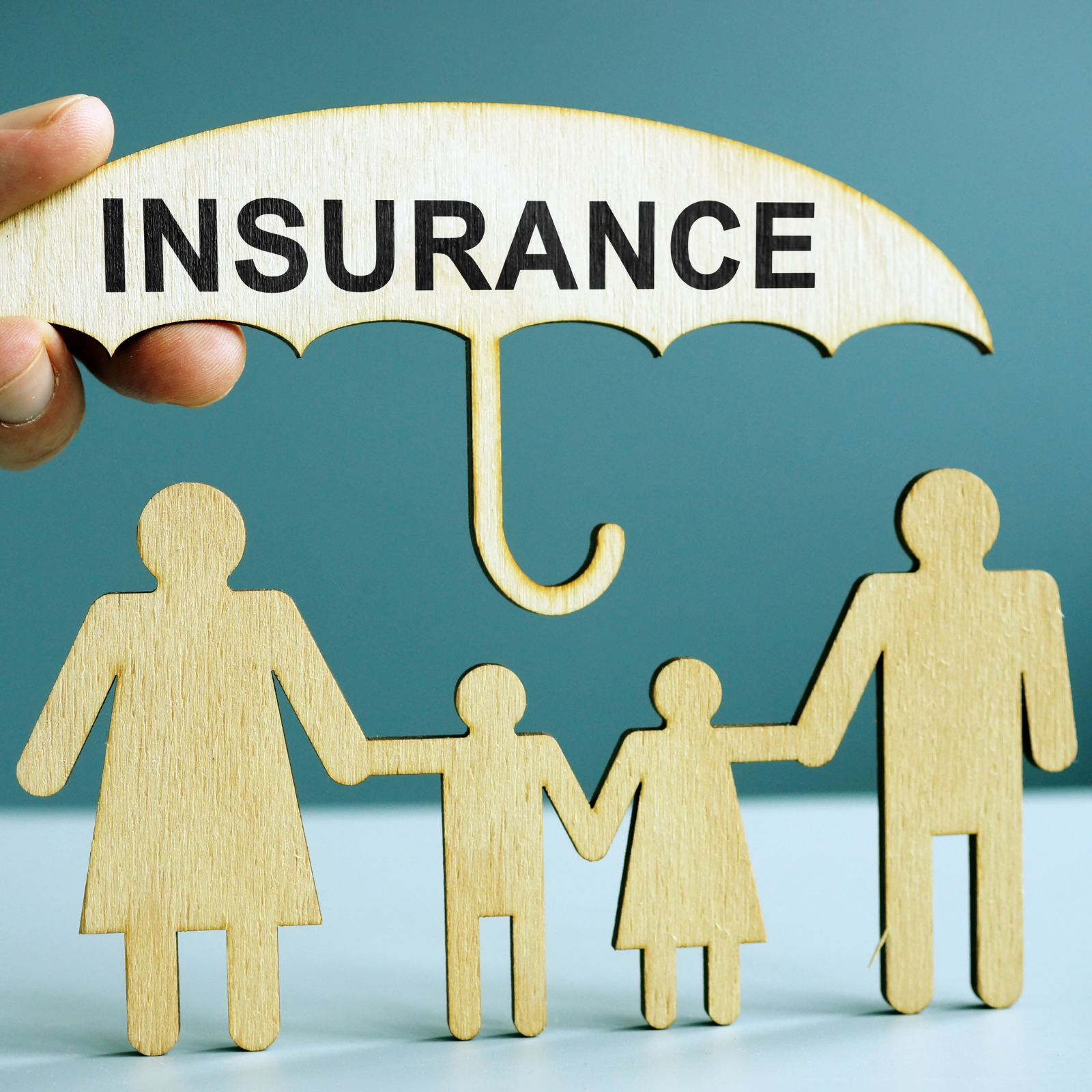 Protecting Families Through Insurance: Building Security with Rachael DeBoy Wooden cutout family figures under an umbrella labeled "Insurance" representing protection and coverage.