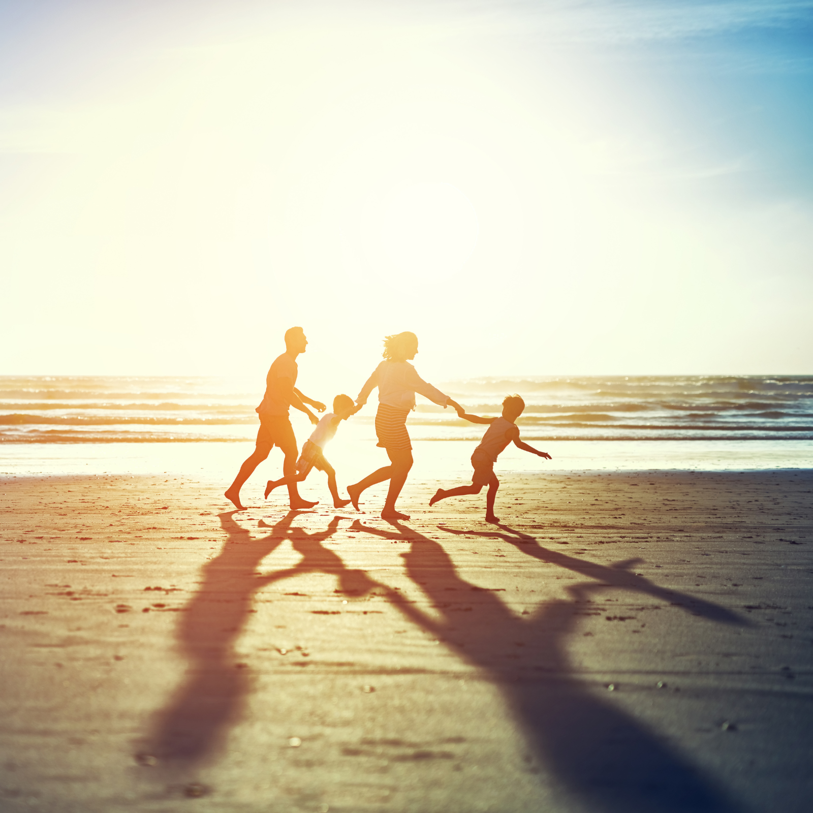 Family Wellness and Vitality with LifeWave Support Silhouetted family running joyfully on the beach at sunset, symbolizing vibrant health and natural wellness support through LifeWave and Rachael DeBoy Wellness.