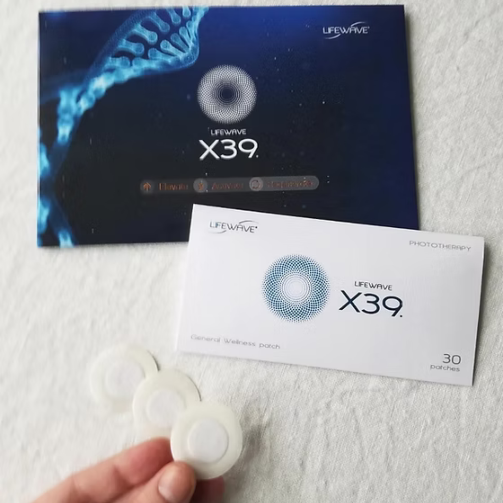 Close-up of LifeWave X39 stem cell patch packaging with three patches in hand on a white background.
