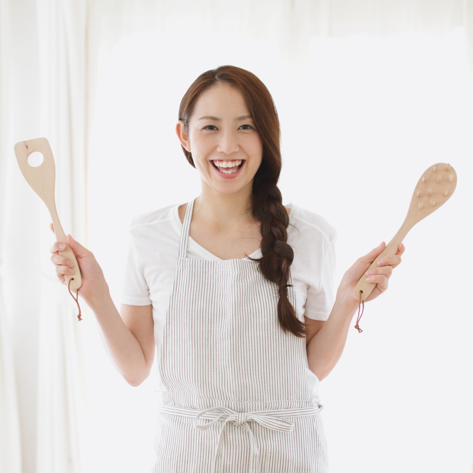 Learn Sourdough Basics with Rachael DeBoy Wellness Smiling woman in striped apron holding wooden spoons, representing Rachael DeBoy Wellness sourdough baking education.