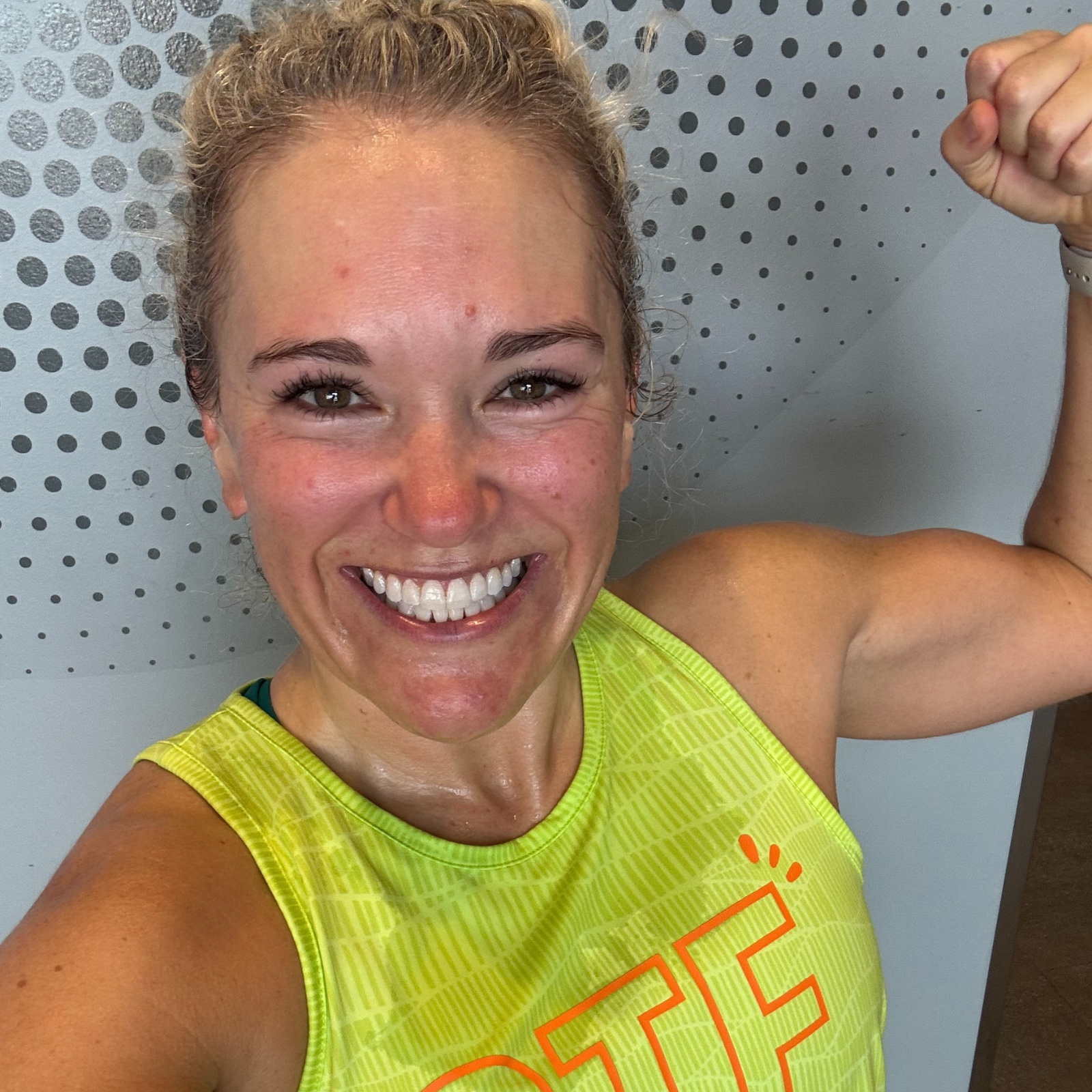 Smiling woman flexing after a workout, highlighting Juice Plus benefits for active lifestyles.