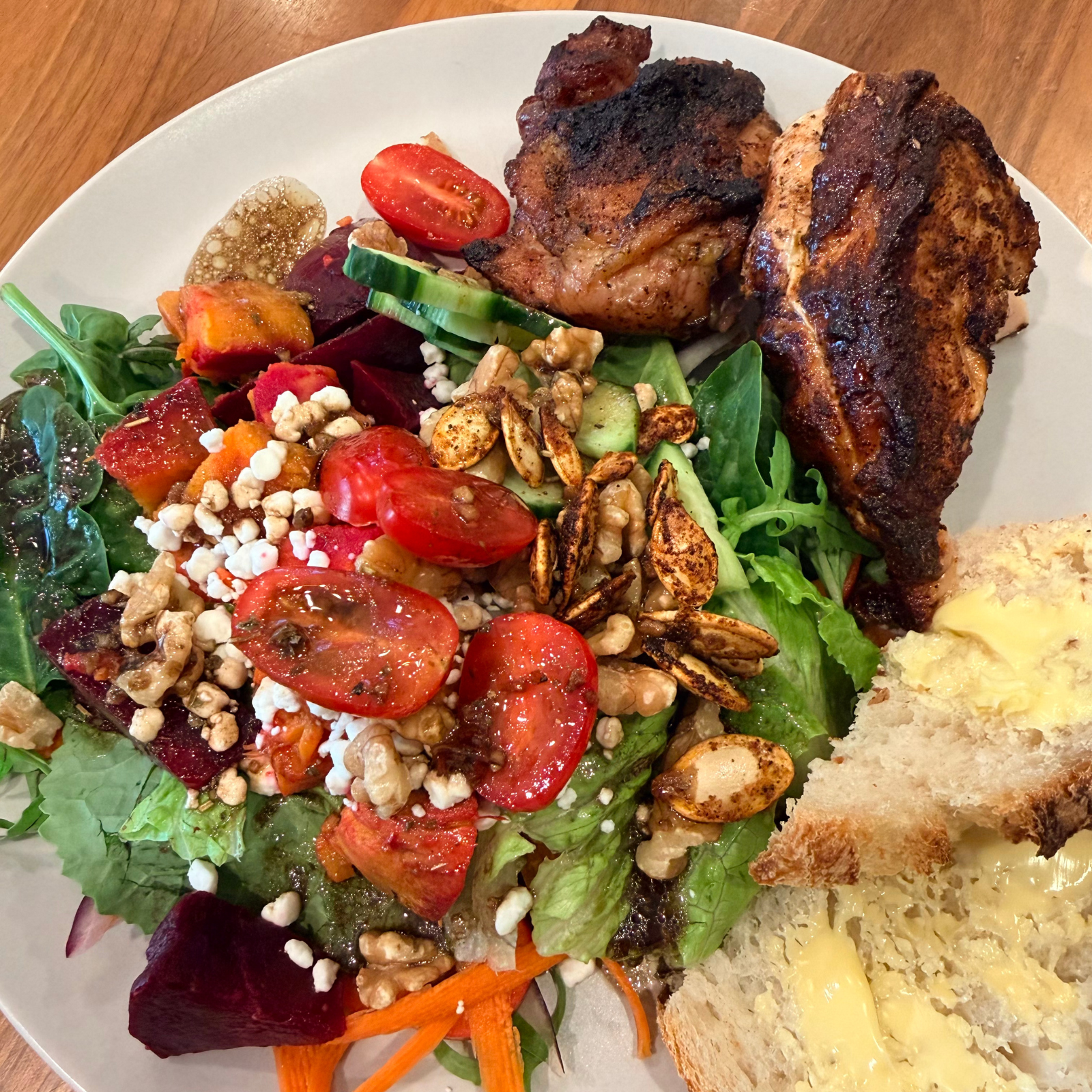 Healthy home-cooked dinner with grilled chicken, colorful salad, and sourdough bread from Rachael DeBoy Wellness in San Antonio, Texas.