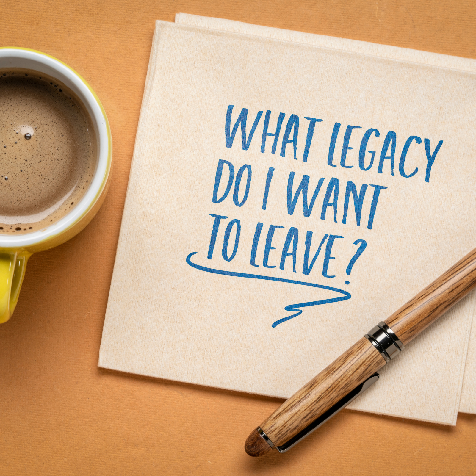 A napkin with the handwritten phrase “What legacy do I want to leave?” next to a cup of coffee and pen, symbolizing reflection on family wealth and purpose.