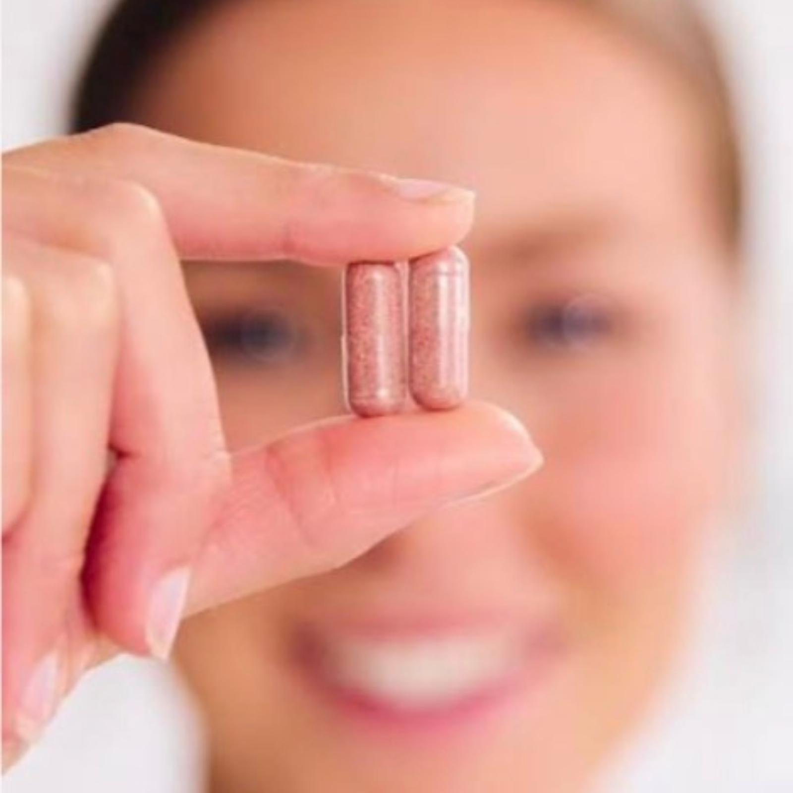 Close-up of hand holding two Juice Plus capsules, emphasizing whole food nutrition