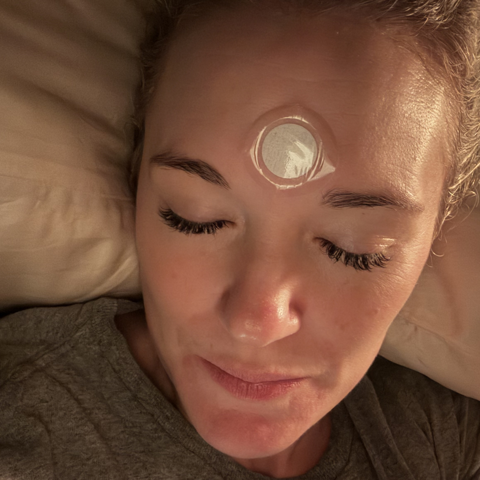 Woman resting with natural sleep support patch applied to forehead